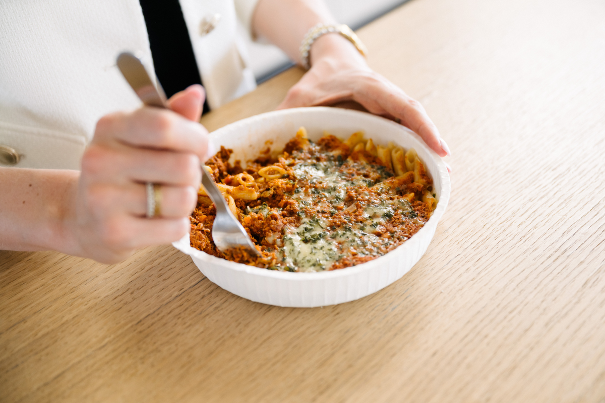 Person mit Gericht vor sich in der Mittagspause am Essen